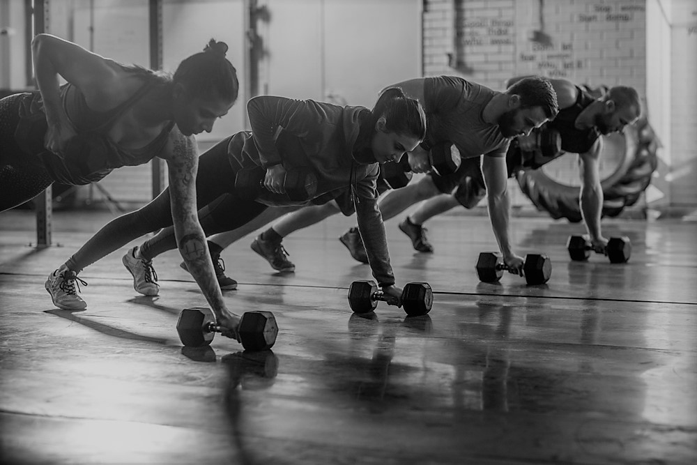 group fitness class involving dumbbells and pushups